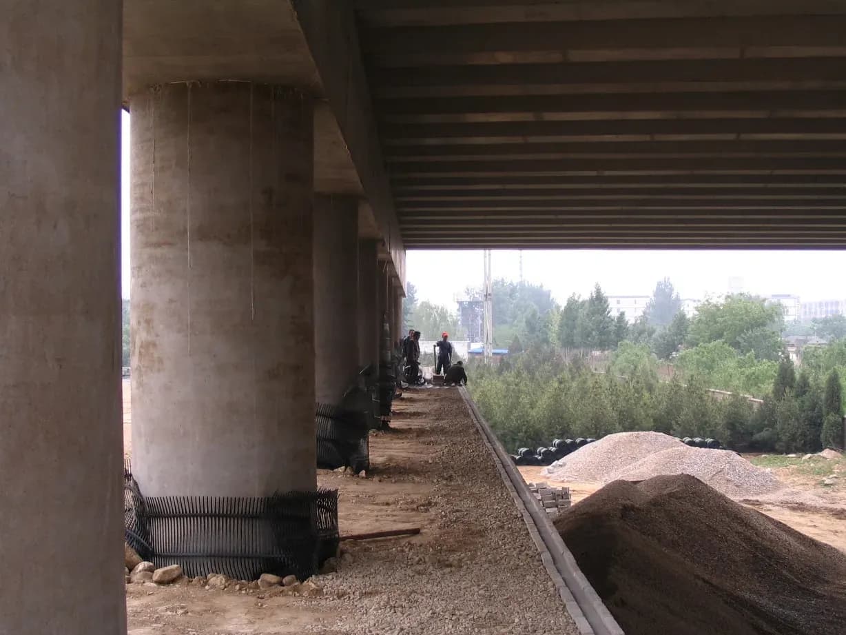 Geogrid rolled out across a prepared platform between viaduct piers before the next fill lift.