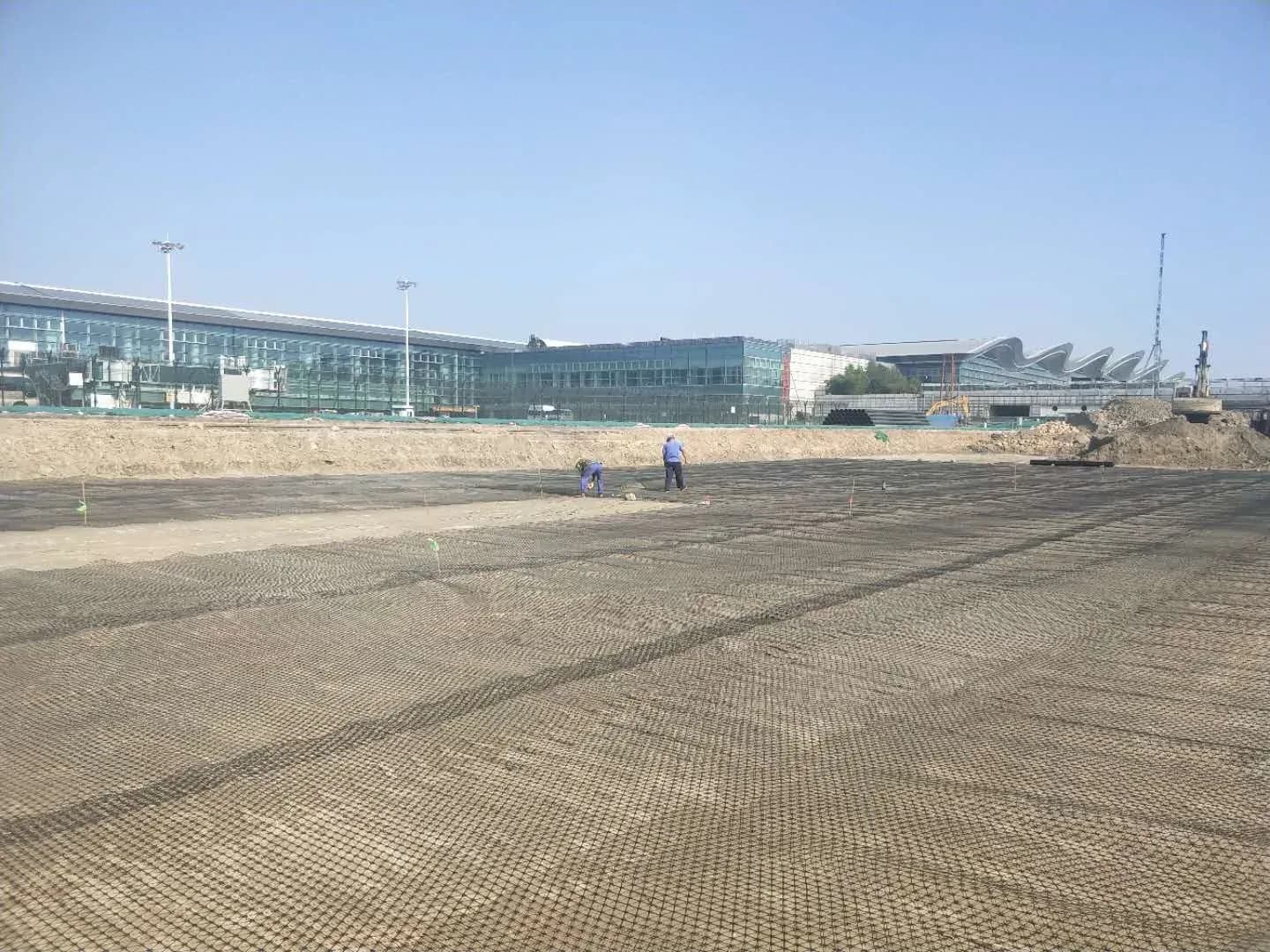 Triaxial geogrid laid out across a large prepared formation before the granular layer goes on.