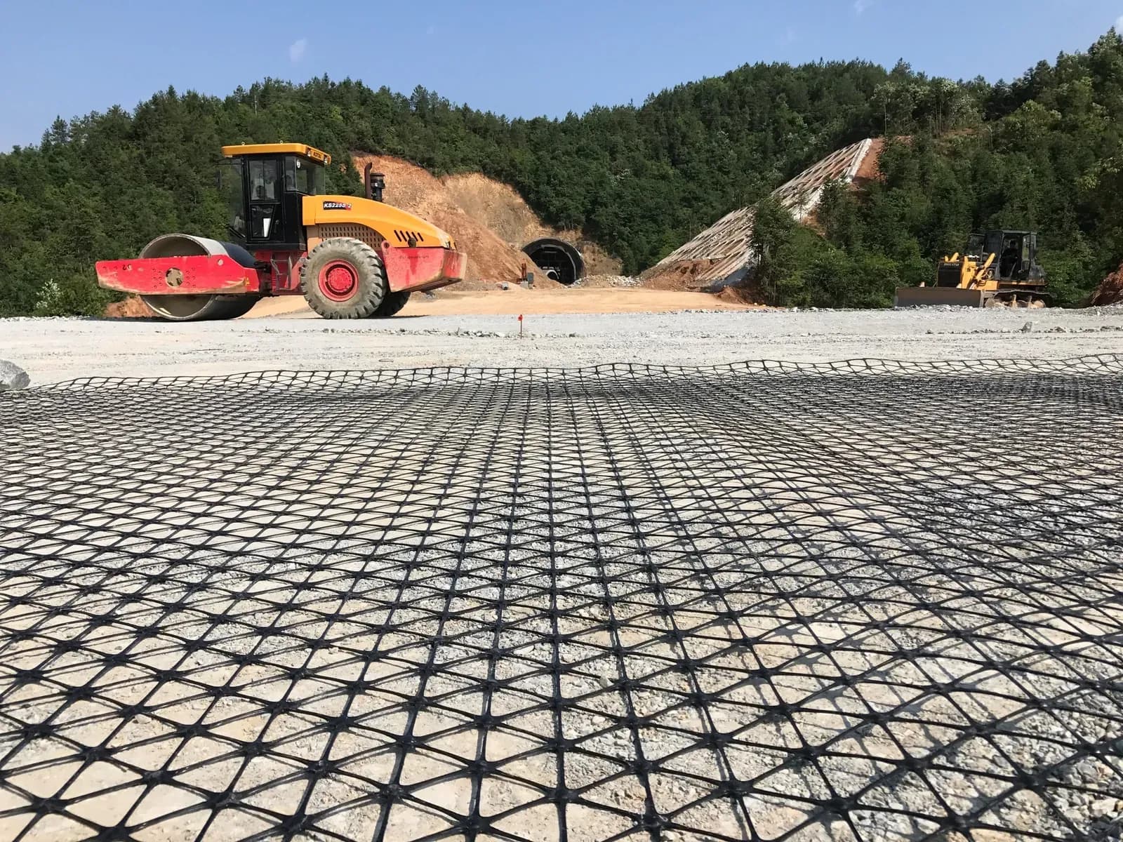 Triaxial geogrid laid across a prepared formation over a wide area and compacted by roller.