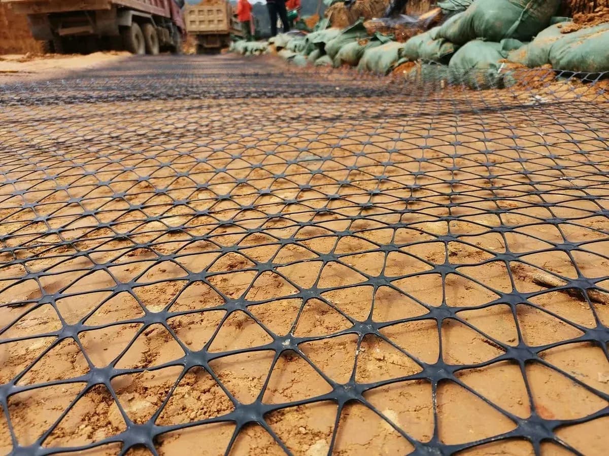 Close view of triaxial geogrid: triangular apertures and rib nodes.